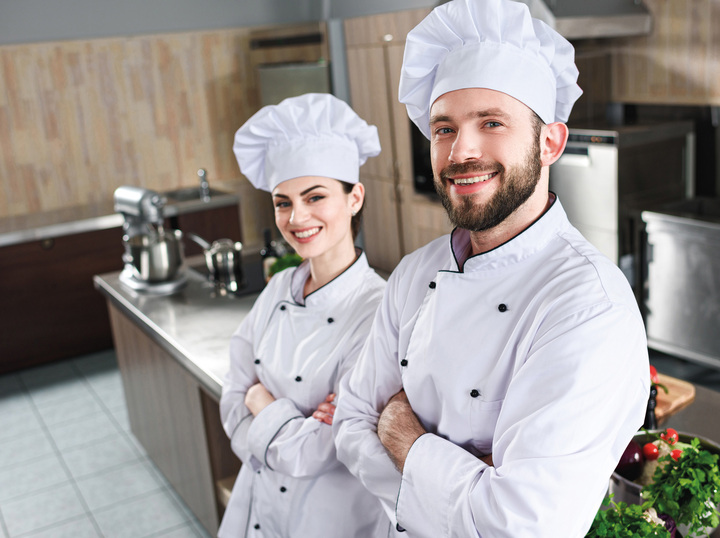 Eine Köchin und ein Koch stehen in der Küche.